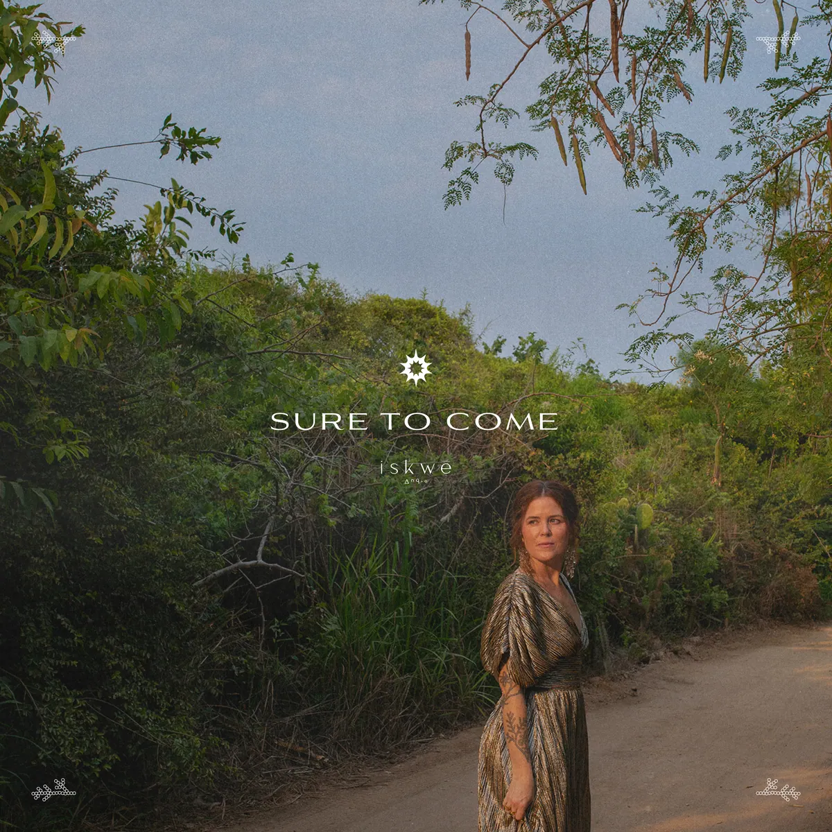 Sure To Come single artwork: iskwē on a dirt path beneath trees